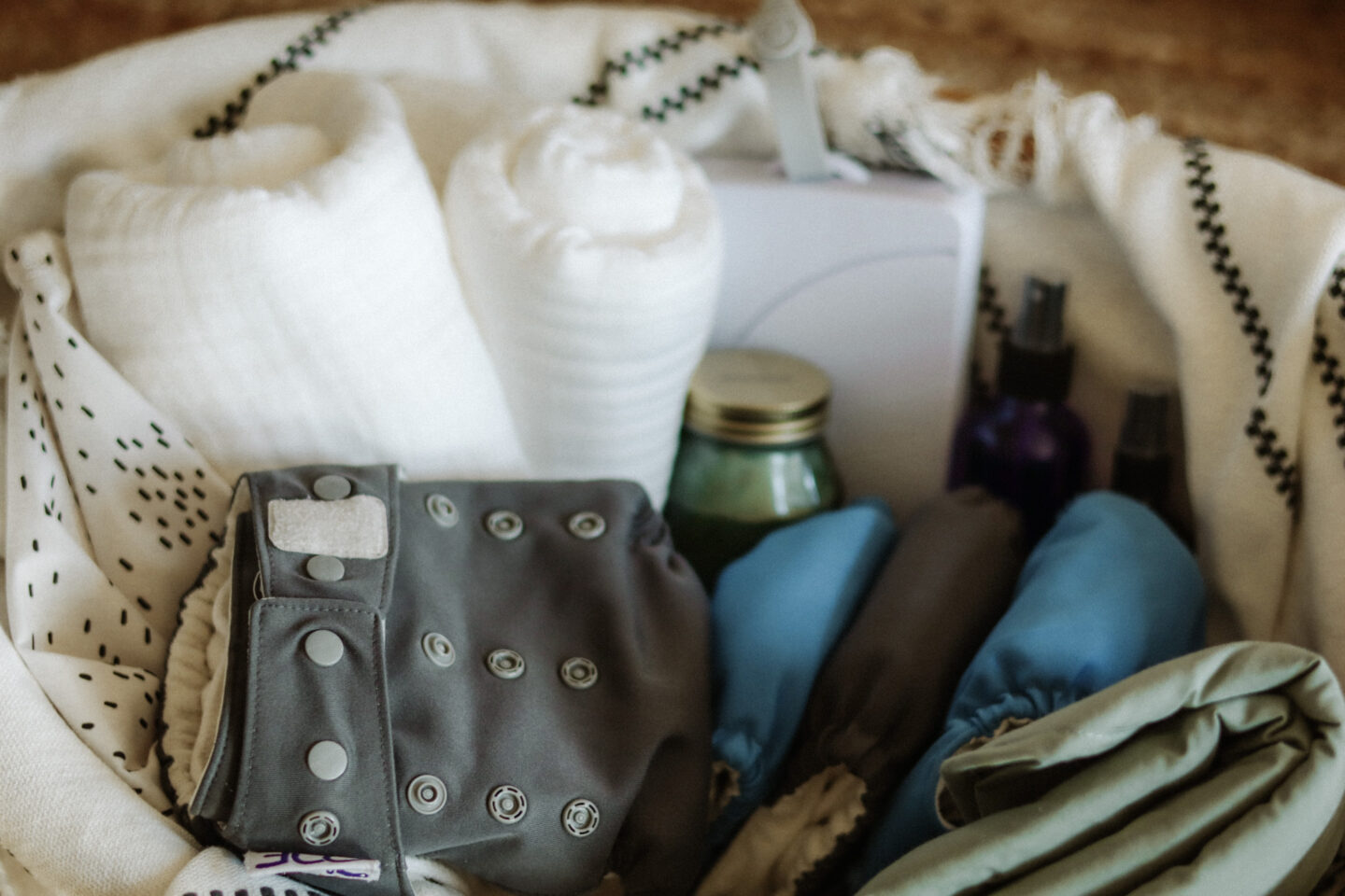 Grovia Cloth Diaper in changing basket with changing pad, burp cloth, wipes, and homemade diaper balm.