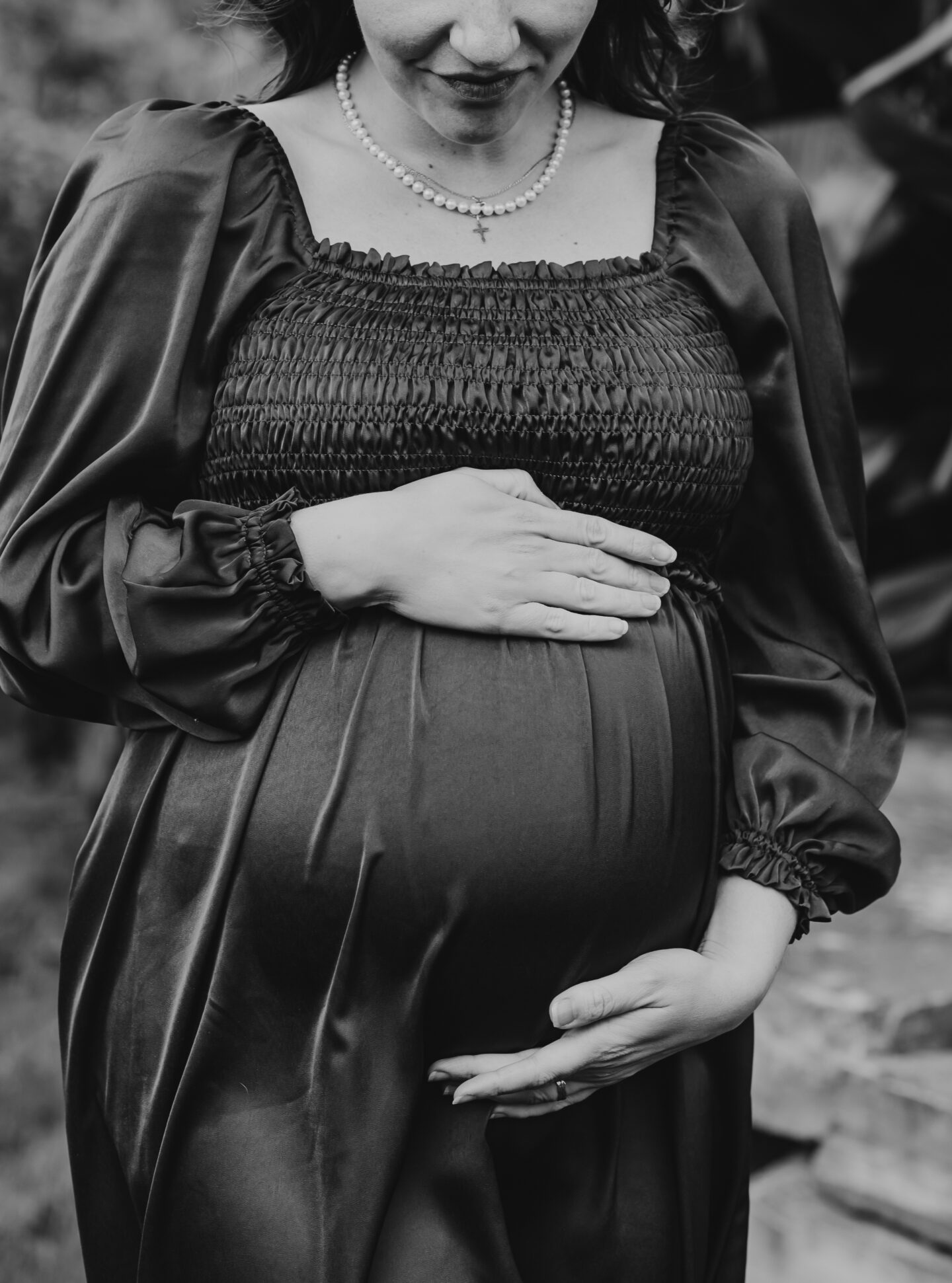 pregnant woman holding belly in maternity dress black and white
