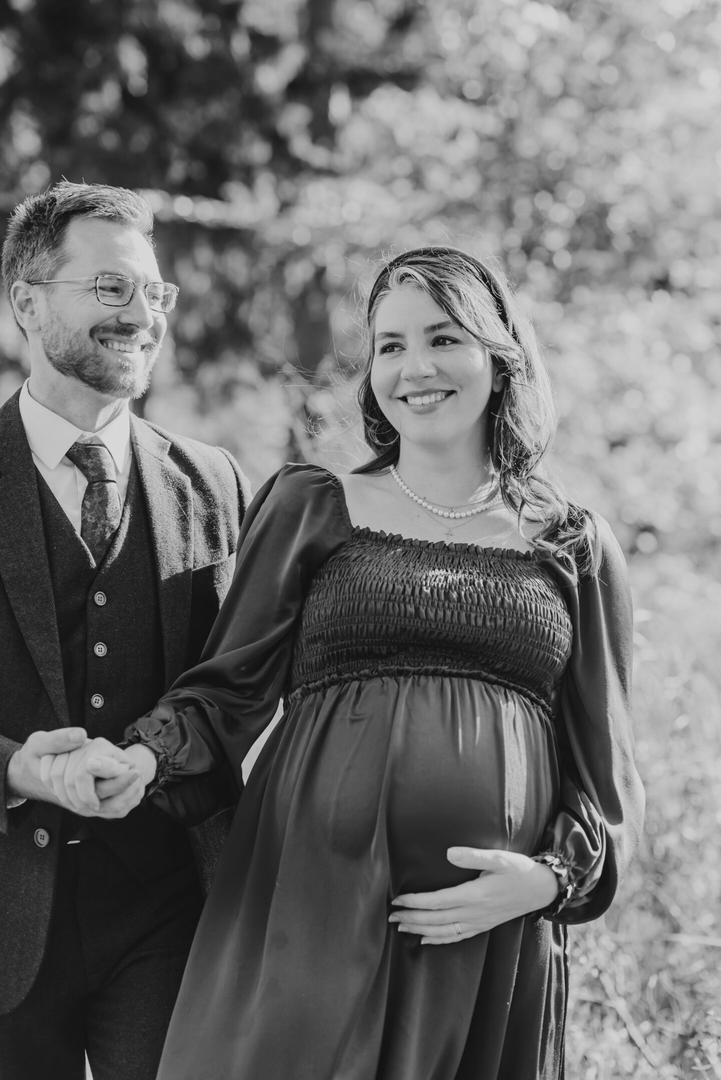 Couple holding hands for maternity photoshoot